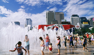 在市政府前廣場噴泉玩水的夏季風景照